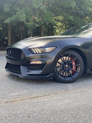 Satin Black full Body wrap + Red Calipers on this Mustang