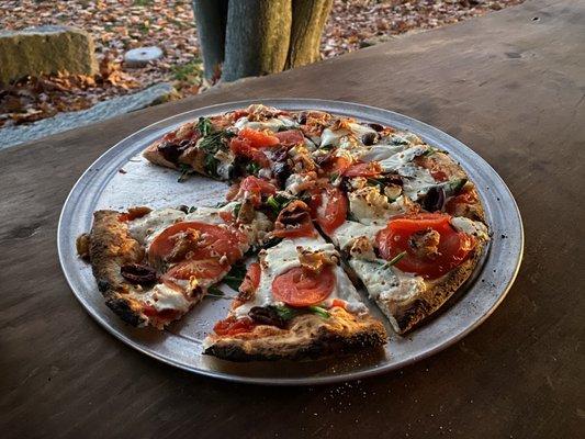 Spinach, tomato, feta and garlic wildfire pizza.