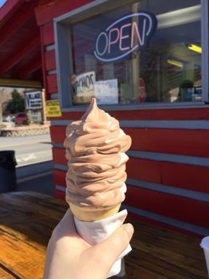 A "small" twisted (chocolate and vanilla) ice cream cone.