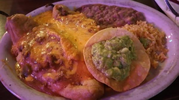 Chile Rellenos dinner served with a side of guacamole, beans, rice, and tortillas.