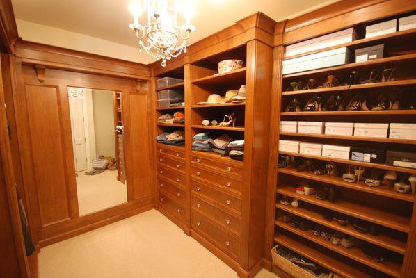 walk in closet with ample shoe storage, large full-length mirror and a chandelier for added style