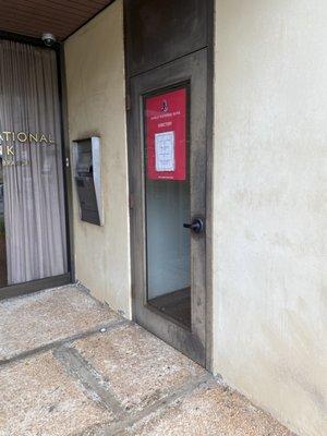 Door is to the right of the bank entrance