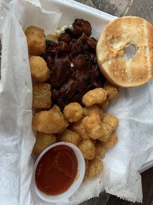 Well done bacon, egg and cheese bagel with tator tots.