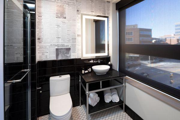 Bathroom of Purple Reign, vinyl wallpaper has newspaper articles of the building