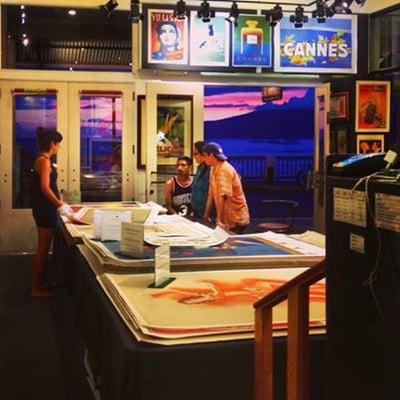 As the Maui sun sets outside, a VEP employee takes some guests through our travel posters.