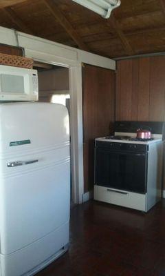 Kitchen has an electric stove too, an old refrigerator with a tiny freezer and a microwave you can plug in