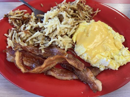 Scrambled breakfast plate, shredded hash browns and bacon