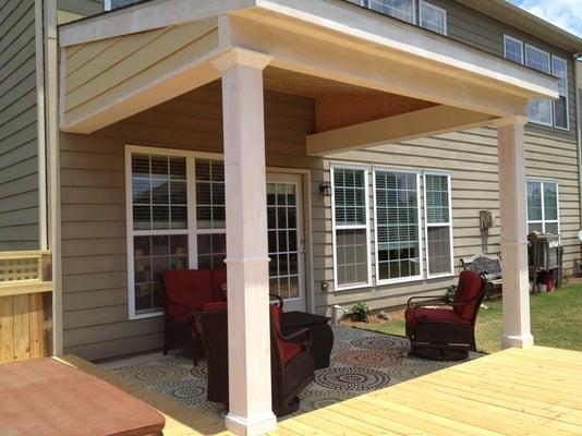 Custom design porch with large deck a recessed hot tub.