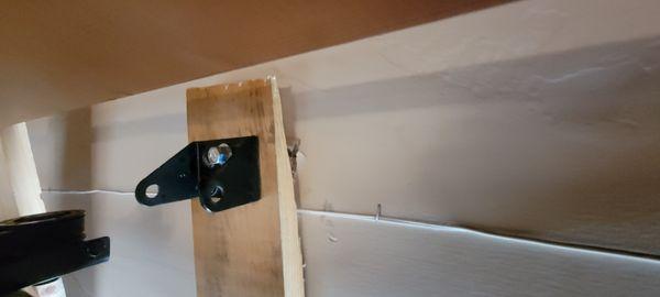 The opener bracket is mounted to the opposite end of the board which is mounted to DRYWALL only!