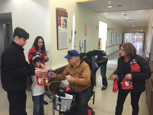 Christmas caroling and passing out holiday gift bags to veterans at the Los Angeles Veterans Affairs hospital.