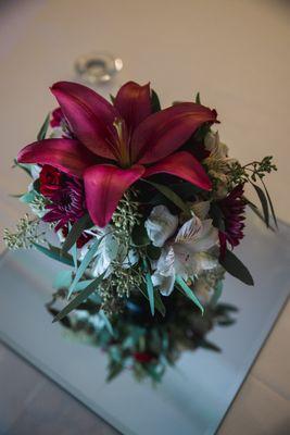 Deep burgundy lily with a few complementary white flowers for a stunning bridesmaid bouquet.