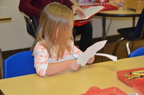 4k student cutting out a Valentine project.