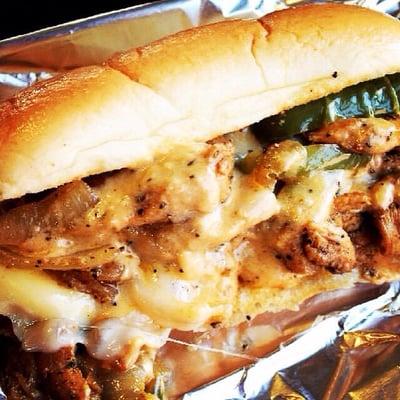 Chicken philly served with onion rings.