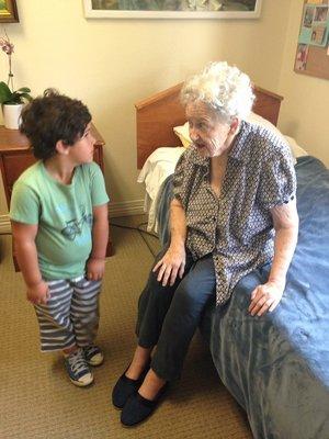 The owner's son helping a local resident at a senior living community find her shoes.