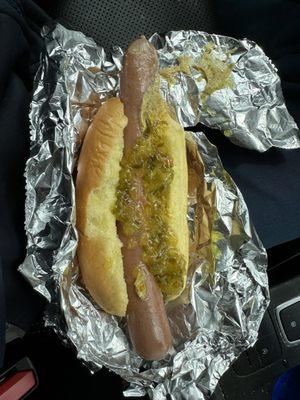 Natural casing hot dog with brown mustard and sweet relish.