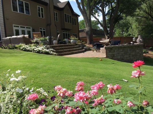 Multi-level Belgard paver patio with firepit, lighting, zoysia lawn, plantings, privacy trees in Roswell, GA by The Inspired Garden.