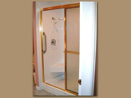 Lovely shower conversion with corner seat, and bronze trim!