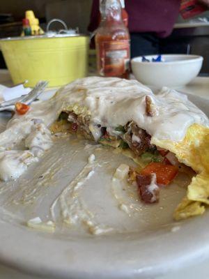 Chicken friend steak omelet with bacon, onions and peppers. Topped with gravy and cheese