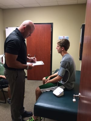 Dr. Ketteler performing a sports physical for a patient.