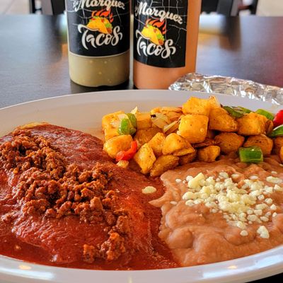 Eggs under the mellow chile sauce, Huevos Rancheros plate at Los Marquez Tacos