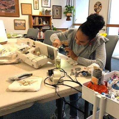 One of our students learning how to take apart and clean a standard home sewing machine, very important!