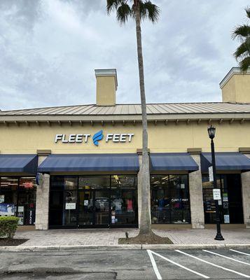 Storefront picture with a palm tree and a few parking spaces.