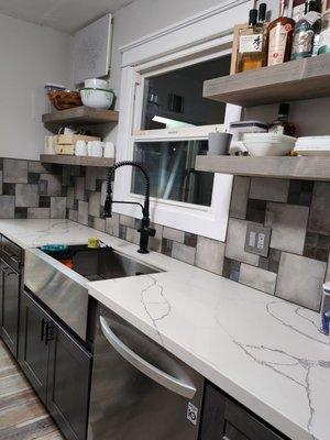 Galley style kitchen with new countertops and tile.