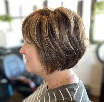 Grey blending, soft mini highlights, and a short textured bob.