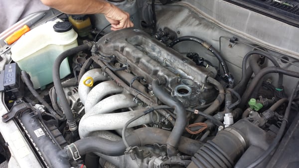 Checking for leaks on a valve cover.