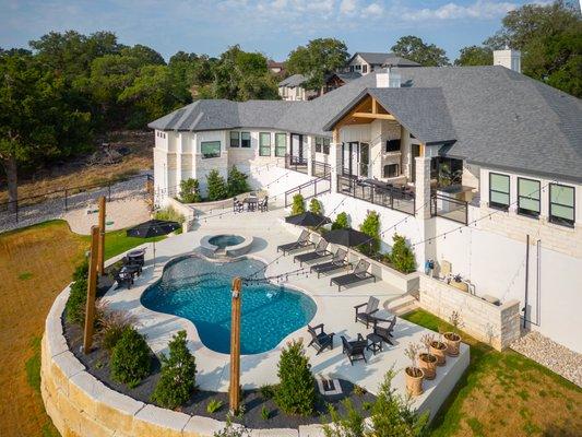 Resort style backyard of a custom home in New Braunfels, TX. Outdoor kitchen, patio, and hot tub. San Antonio Custom Home Builder