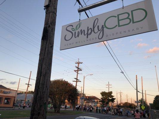 Second line passes by Simply CBD in the Marigny