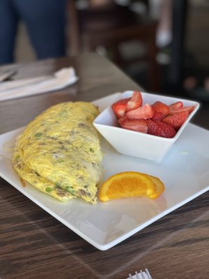 Meat lovers omelet with a side of strawberries