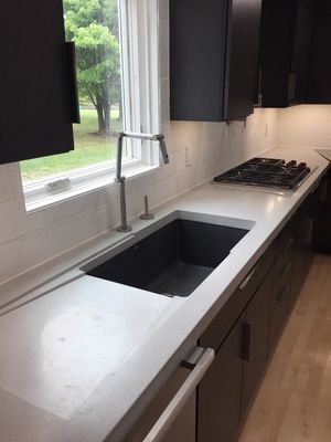 Kohler carbon kitchen faucet, with concrete counter tops.