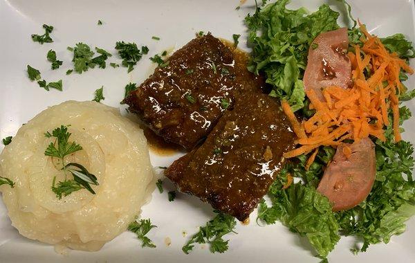 Costillas de cerdo en salsa BBQ acompañado de yuca al mojo y ensalada