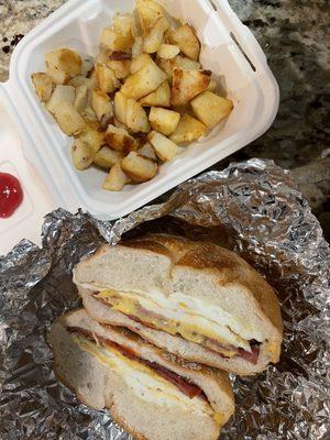 Taylor ham, egg & cheese breakfast sandwich with a side of potatoes.