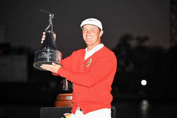 Bryson DeChambeau wearing Arnold Palmer's iconic red cardigan after winning the 2021 API.