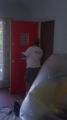 Painting my front door. He covered all of my living room furniture as well as the flooring!