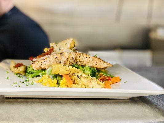 Pan-seared Salmon with sun-dried tomatoes, roasted artichoke and lemon garlic sauce. Served with rice and veggies.