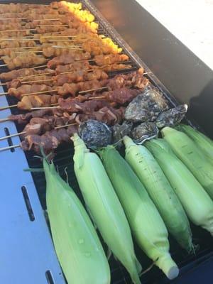 Grilled oysters, corn, rice plates and skewers