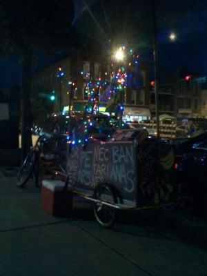 fruit cart lit up at night. pulled by trike