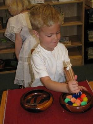 Transferring items from one bowl to another using chopsticks.