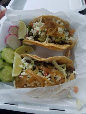 Steak tacos with lettuce, pico,cheese and grilled onions.