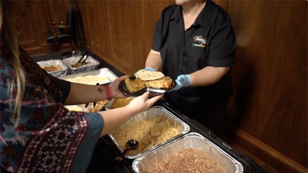 Ventura's Tamales serving someone at a catered event.