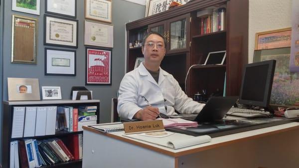 Dr. Hoenie Luk at his desk