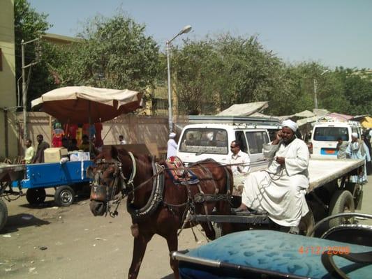 Egypt's Merging of Ages (UsingCellPhone as pulls Supplies by Horse, TraditionalDress