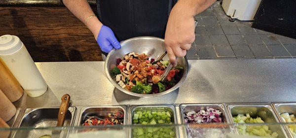 Salad being prepared with the ingredients you choose