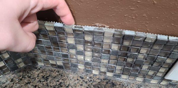 Loose backsplash from them removing countertop