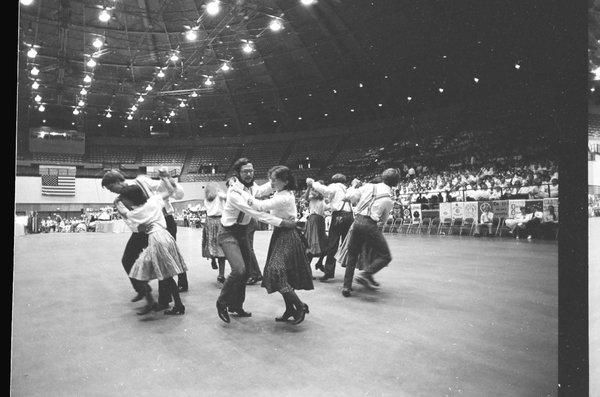 Kickapoo Cloggers perform at Dane County Coliseum.  You can see many people in audience.