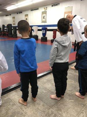 Master Lee explains to the beginner evaluation class the procedures before they step onto the mat.