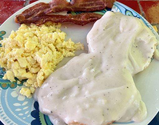 Biscuits and gravy with scrambled eggs and bacon.